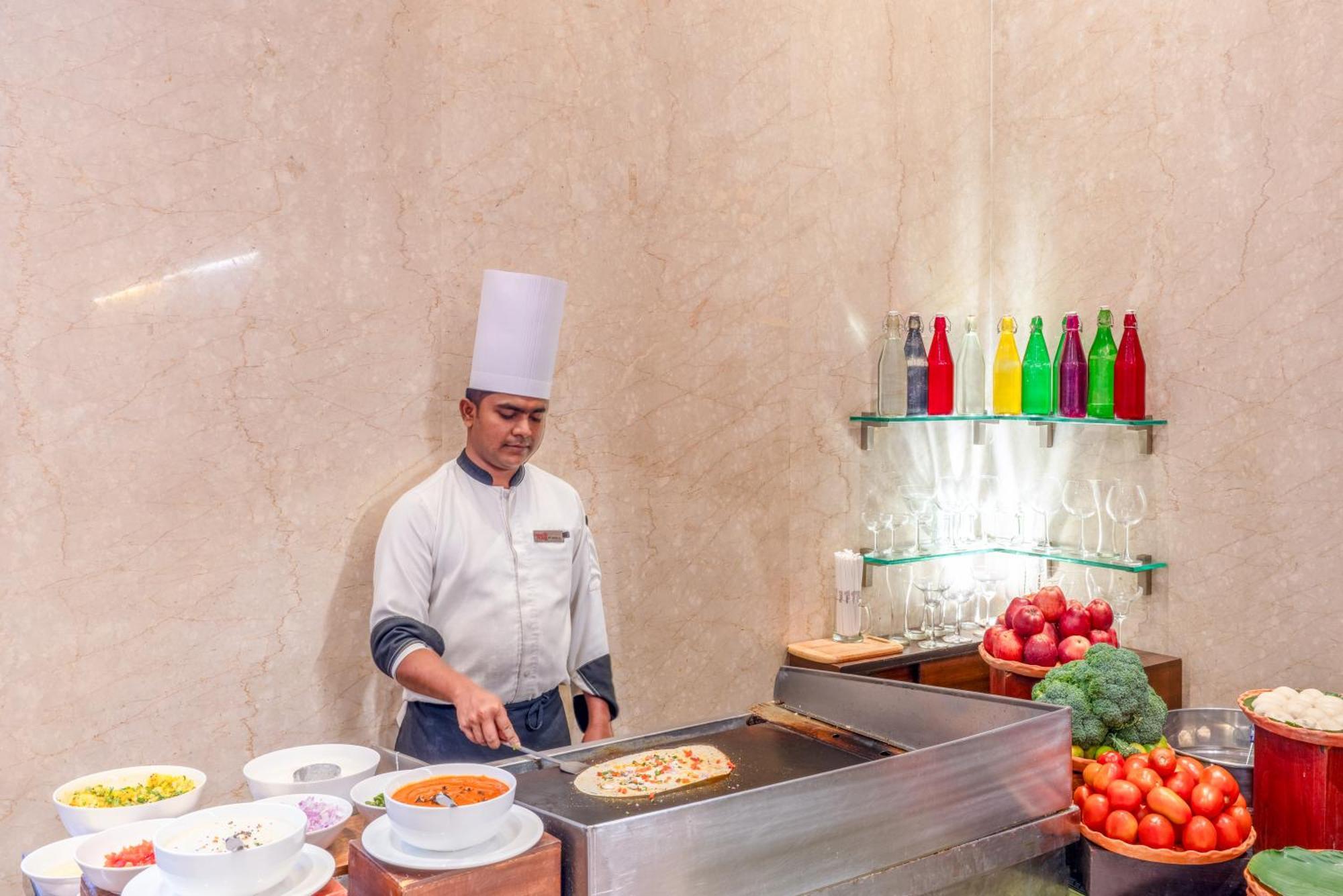 加尔各答普赖德广场酒店 外观 照片 A chef preparing food at a buffet